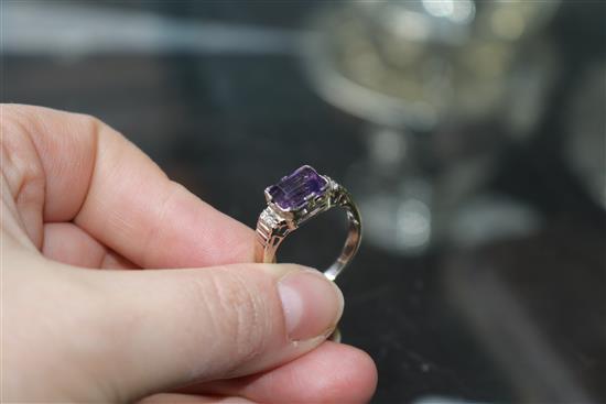 An 18ct white gold and emerald cut amethyst ring with diamond set shoulders, size P.